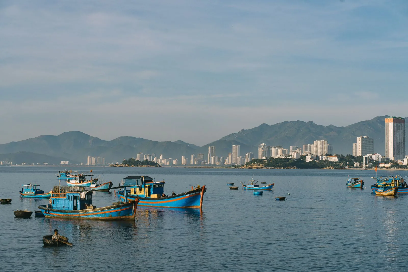 Thuyền cá nhiều màu trên vịnh Nha Trang với skyline thành phố phía sau