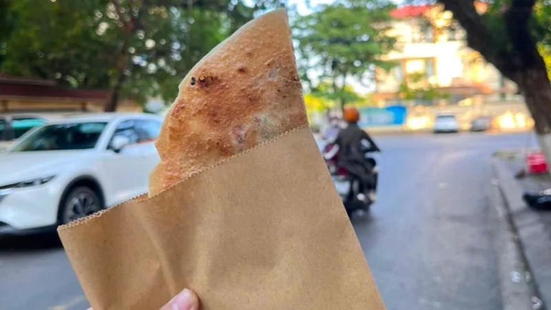 Bánh xèo giòn gói giấy mua từ quán vỉa hè trên đường phố Đồng Hới, Quảng Bình